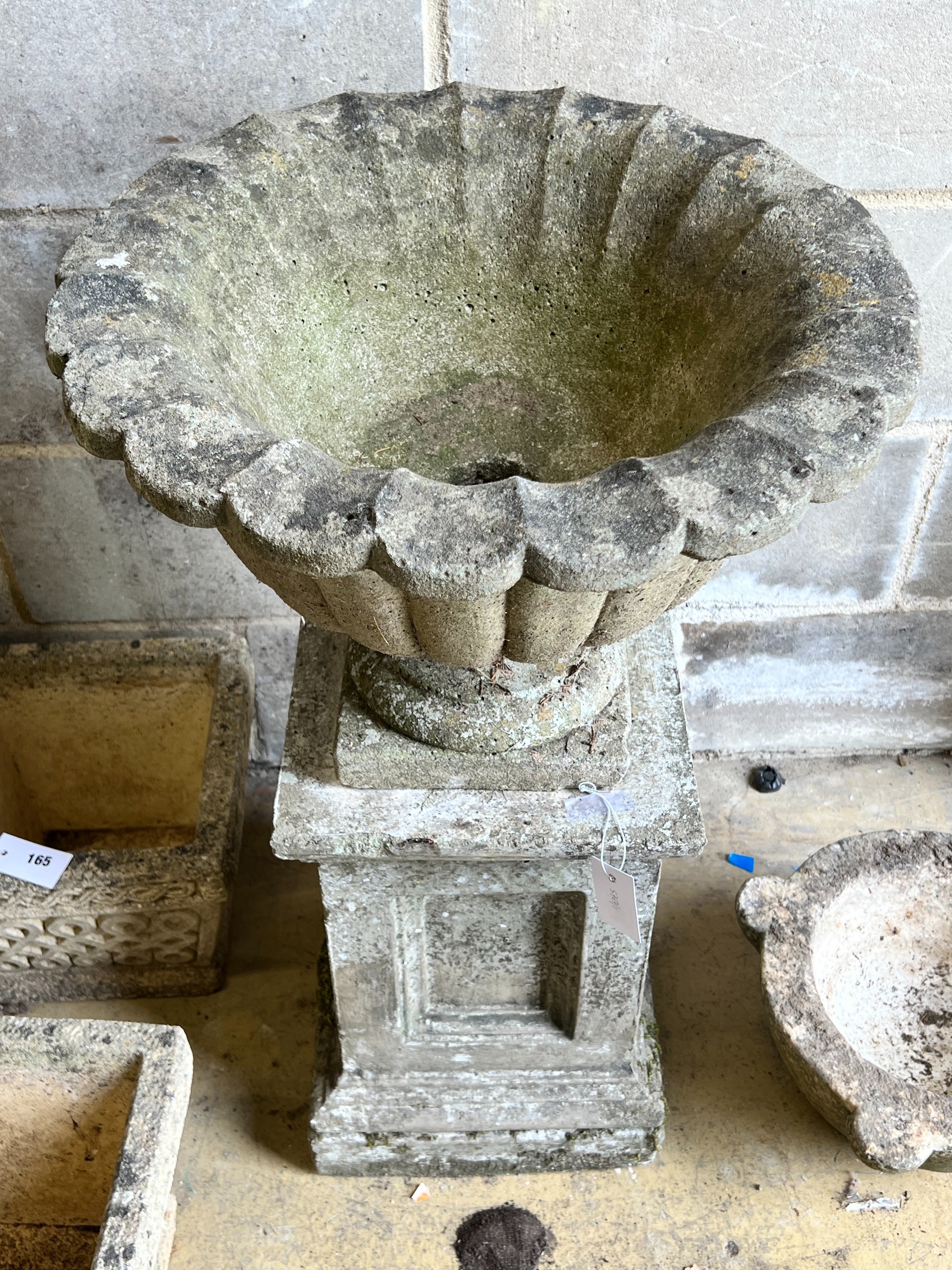 A reconstituted stone campana garden urn on square plinth, diameter 49cm, height 82cm